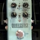 Světle modrý efekt pedál s nápisy QUINTESSENCE HARMONY a tc electronic. Na horní části jsou tři černé otočné ovladače s popisky KEY, SCALE a MIX, dál…