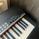 Detailní záběr na klávesový nástroj v černé barvě. Na horním panelu je nápis CP4 STAGE a sekce MASTER EQUALIZER s posuvníky označenými jako LOW MID,…