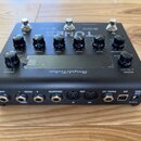 Černý kytarový procesor s nápisem TONEX a AmpliTUBE. Na horní straně jsou tři stoupavé spínače a šest otočných knoflíků s popisky VOLUME, TREBLE, MID…