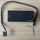 Černý obdélníkový modul s nápisem EMG-HZ. Z modulu vychází černý kabel, který je na pravé straně přerušen a má odkryté červené a zelené vodiče. Na le…