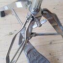 Detailní pohled na kovový mechanismus basového pedálu v chromovaném provedení. Na šedé plastové stupňovací ploše je viditelný nápis THUNDER. Povrch k…
