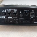 Zadní strana černého kytarového efektu s nápisem DigiTech a poznámkou DESIGNED IN THE USA. Jsou zde viditelné konektory s popisky INPUT, AMP MIXER, L…