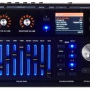 Černý elektronický bicí modul s displejem a ovládacími prvky. Na horním panelu jsou nápisy POWER, DC IN, DIRECT OUT, LINE OUT, LINE IN, USB a TRIGGER…