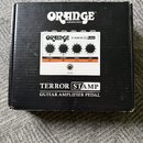Černá krabice s bílými nápisy. Na horní části je logo ORANGE AMPLIFICATION a uprostřed obrázek pedálu s nápisem ORANGE TERROR STAMP. Dole je uveden n…