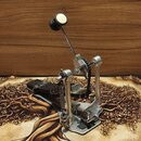 Fotografie znázorňuje basový pedál v kovovém provedení s černými plošinkami. Mechanismus je poháněn řetězem a vybavený je kovovou pákou s černým knof…