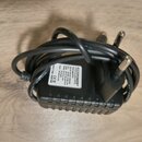Černý síťový adaptér s přiloženým kabelem. Na bílém štítku je uveden nápis ROCKPOWER®, Power Supply RP12 a vstupní napětí Input: 100-240V~50/60Hz 0.5…
