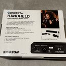Fotografie znázorňuje krabici od bezdrátového systému s nápisy CONCERT 88x HANDHELD Frequency-Agile UHF Wireless System. Na obalu je logo SAMSON a te…