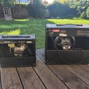 Dvě kytarové reprobedny s černým povrchem umístěné na dřevěné terase. Menší bedna vlevo nese nápisy V-TONE GM108 a BEHRINGER. Větší bedna vpravo má l…