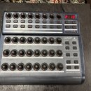 Modrý USB MIDI kontrolér s třemi řadami otočných knoflíků a řadou tlačítek. Na horním panelu je červený digitální displej s nápisem P-10 a nápisy VAL…
