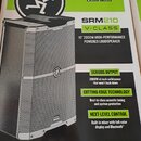Fotografie krabice s produktem, na které je zobrazen černý aktivní reproduktor s kovovou mřížkou. Na krabici jsou viditelné nápisy SRM210, V-CLASS a…