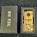 Zlatý efekt pedál v černé krabičce s nápisem MINI PEDAL. Na pedálu jsou viditelné nápisy 9V DC, LEVEL, L O PER a M-VAVE. Obsahuje jeden regulační kno…