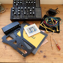 Na fotografii jsou dva černé syntezátory s nápisem Moog, z nichž na spodním je uveden model MOTHER-32 SEMI MODULAR ANALOG SYNTHESIZER. Součástí sady…