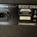 Fotografie zachycuje černý plastový štítek s technickými údaji na zadní straně přístroje. V horní části je bílé logo Ampeg a označení BA-108 v2. Štít…