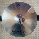 Kovový činel stříbrné barvy s viditelným broušením povrchu. V horní části je trojúhelník a nápis XIST, pod ním menší text 15" Brilliant Hi-Hat. Ve sp…