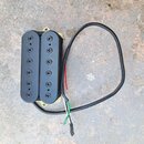 Černý humbucker s dvěma řadami po šesti pólech. Snímač je umístěn v žlutém plastovém rámečku a vede od něj černý kabel s odkrytými červeným, bílým a…