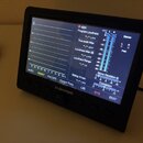 Černý měřicí přístroj s displejem a ovládacími tlačítky. Na spodní hraně šasi je bílý nápis tc electronic. Displej zobrazuje analýzu zvuku s hodnotam…