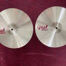 Dva kovové činely v přirozené zlatavé barvě s viditelným broušením povrchu. Na levém činele je nápis „paiste psX 14" HEAVY HI-HAT TOP“. Na pravém čin…