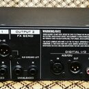 Černý rackový procesor s nápisem FRACTAL AUDIO SYSTEMS. Zadní panel obsahuje různé vstupy a výstupy označené jako INPUT 1, INPUT 2 FX RETURN, OUTPUT…