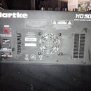 Zadní strana černého basového komba s nápisy Hartke a HD 508 500W BASS AMPLIFIER. Na zadním panelu jsou umístěny ventilační mřížky, chladicí ventilát…