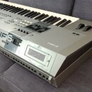 Stříbrný digitální klavír s nápisem YAMAHA MOTIF6 na levé straně. Na pravém boku je viditelné logo YAMAHA. Nástroj má klávesnici, několik ovládacích…