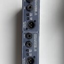 Detailní pohled na zadní panel stříbrného audio zařízení s dvěma kanály. Viditelný je CHANNEL A a CHANNEL B, každý vybaven konektory INPUT, LINK a BA…