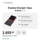 Fotografie znázorňuje dřevěný stompbox v černé barvě s hranatým tvarem a zkosenou horní plochou. Horní část je zakončena černým protiskluzovým povrch…
