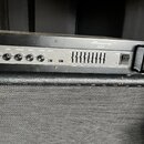 Černý basový zesilovač s nápisy Ampeg a B2R. Na předním panelu jsou ovládací knofíky s popisky GAIN, ULTRA MID, TREBLE, MASTER a LIMITER. Přístroj má…