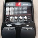 Černý kytarový procesor s nápisem RP 155 MODELING GUITAR PROCESSOR. Zařízení má digitální displej s červeným číslem 5, několik ovládacích tlačítek a…
