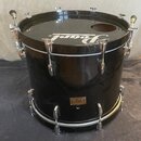 Černý buben s kovovými obručemi a napínacími šrouby. Na horní straně je bílý nápis Pearl a v dolní části zlatý štítek s textem Pearl Master Studio. P…
