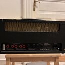 Zadní strana černého kytarového komba s hnědou mřížkou reproduktoru. Na zadním panelu je nápis Marshall a modelové označení MODEL DSL AMPLIFIER 20 PL…