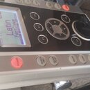 Stříbročerný perkusní modul s displejem a ovládacími prvky. Na horní části je nápis Roland a PERCUSSION SOUND MODULE TD-9. Displej zobrazuje text Lat…