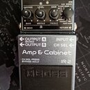 Stříbrný kytarový pedál značky BOSS s nápisem IR-2 Amp & Cabinet. Na levé straně jsou čtyři černé otočné oválkové knoflíky s popisky GAIN, LEVEL, AMB…