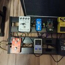 Černý efektový pedalboard s několika kytarovými efekty. V horní řadě jsou pedály s nápisy „JOYO Classic Flanger“, „Big Foot“ a „SUPER Over D“. V doln…
