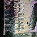 Detailní pohled na chromovaný kobylku elektrické kytary s šesti sedly. Na základní desce je u každého sedla vyryt nápis PAT. PEND. Povrch je vysoce l…