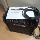 Černý kytarový kombozesilovač s nápisem LINE 6 a označením modelu SPIDER IV 15. Na horním ovládacím panelu jsou umístěny ovratové knofíky a přepínače…