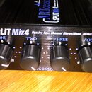 Černý mixér s nápisem SPLIT Mix4 a doplňujícím textem Passive Four Channel Stereo/Mono Mixer/Splitter. Na přední straně jsou čtyři černé oválné ovlad…