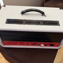 Zadní strana kytarového komba s bílým povrchem z vinylu a černou ventilační mřížkou. Spodní červený panel obsahuje nápisy SERIAL LOOP (SEND, RETURN),…