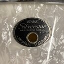 Detail bubnu s bílým perleťovým povrchem a chromovanými obručemi. Na korpusu je oválný černý štítek s nápisy TAMA, Silverstar a ALL BIRCH SHELL. V pr…