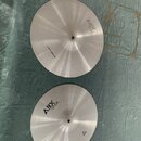 Dvě stříbrné kovové činely s viditelným rýhováním povrchu. Oba mají nápis ABX cymbals. Na horním činele je dále text TYP-48CM CRASH/RIDE a na spodním…