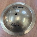 Kulatý mosazný činelec typu zvonek s otvorem uprostřed. Na povrchu je černý nápis ZIL-BEL a logo Zildjian s doplňkem SOUND EFFECTS. Povrch je lesklý…