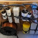 Fotografie zachycuje vnitřek elektronického zařízení s komponenty rozmístěnými na hnědém deskovém podkladu. Jsou zde vidět dva velké měděné transform…