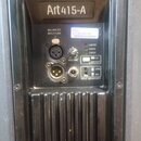 Záběr na zadní panel černého aktivního reproduktoru s nápisem Art415-A. Panel obsahuje dva XLR konektory, jeden jack konektor a ovrtový regulátor VOL…
