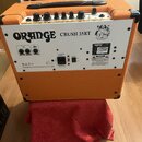 Zadní strana oranžového kytarového komba s bílým zadním panelem. Na panelu je nápis ORANGE CRUSH 35RT a logo značky Orange. Jsou zde vidět ovládací p…