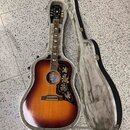 Akustická kytara s tělem typu dreadnought v barevné variantě sunburst, umístěná v otevřeném tvrdém kufru. Na hlavě je viditelné logo „Kepma“. Kytara…