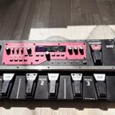 Černý loop pedal s červeným ovládacím panelem a stříbrným rámem. Na panelu je nápis BOSS RC-300 LOOP STATION a digitální displej. Zařízení má v předn…