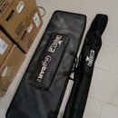Na fotografii jsou dva černé textilní transportní obaly. Větší obal má bílý nápis „CHAUVET DJ Gigbar2“ a menší, úzký obal nápis „CHAUVET DJ“. Povrch…