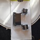 Na bílém podkladu v plastovém obalu je kovové příslušenství černé barvy. Na horním žlutozeleném pásu je nápis MAPEX a v rozích texty BASS DRUM LIFT a…