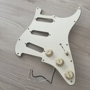 Bílá pickguard pro elektrickou kytaru s třemi výřezy pro snímače. Je na ní osazeno tři ovládací knofíky s nápisy TONE, TONE a VOLUME a jeden přepínač…