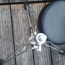 Černý kulatý sedák na chromovaném třínožném stojanu. Stojan má v dolní části černé gumové zátěrky na koncích nohou. Na kovových a polstrovaných částe…