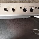 Detail zadní strany stříbrného zařízení s nápisem ROLLER BOARD. Jsou zde vidět dva jack konektory označené jako SWITCH 2 a SWITCH 1 oraz dva MIDI por…